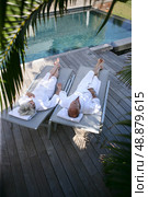 Couple lounging by a pool. Стоковое фото, агентство Ingram Publishing / Фотобанк Лори