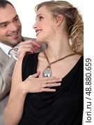 Man attaching his wife&rsquo;s necklace. Стоковое фото, агентство Ingram Publishing / Фотобанк Лори