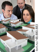 Architect showing scale model of house to buyers. Стоковое фото, агентство Ingram Publishing / Фотобанк Лори