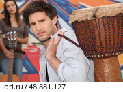 Young man carrying a djembe. Стоковое фото, агентство Ingram Publishing / Фотобанк Лори