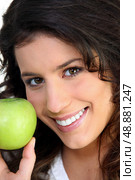 Brunette woman and an apple. Стоковое фото, агентство Ingram Publishing / Фотобанк Лори