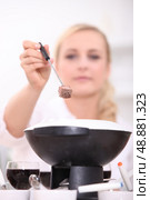 Woman eating a fondue bourguignonne. Стоковое фото, агентство Ingram Publishing / Фотобанк Лори