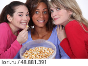 Peppy women eating popcorn. Стоковое фото, агентство Ingram Publishing / Фотобанк Лори