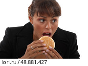 Businesswoman biting a burger. Стоковое фото, агентство Ingram Publishing / Фотобанк Лори
