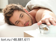 Man turning off alarm clock. Стоковое фото, агентство Ingram Publishing / Фотобанк Лори