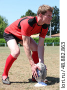 Man stood on rugby pitch preparing penalty kick. Стоковое фото, агентство Ingram Publishing / Фотобанк Лори