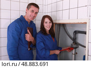 Plumber and female apprentice smiling. Стоковое фото, агентство Ingram Publishing / Фотобанк Лори