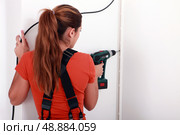 Woman drilling into wall. Стоковое фото, агентство Ingram Publishing / Фотобанк Лори