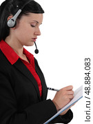 Woman with headset writing on notepad. Стоковое фото, агентство Ingram Publishing / Фотобанк Лори