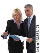 A team of business professionals discussing a report. Стоковое фото, агентство Ingram Publishing / Фотобанк Лори