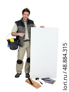 Tiler pointing at blank advertising panel. Стоковое фото, агентство Ingram Publishing / Фотобанк Лори