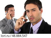 Two businessmen on their mobile telephones. Стоковое фото, агентство Ingram Publishing / Фотобанк Лори