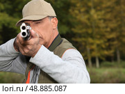 Hunter looking down the barrel of a gun. Стоковое фото, агентство Ingram Publishing / Фотобанк Лори