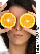 Hiding her eyes with oranges. Стоковое фото, агентство Ingram Publishing / Фотобанк Лори