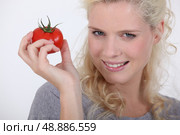 a blonde woman holding a tomato in her hand. Стоковое фото, агентство Ingram Publishing / Фотобанк Лори