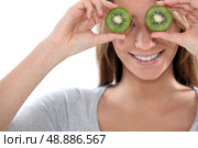 Woman covering her eyes with slices of kiwi. Стоковое фото, агентство Ingram Publishing / Фотобанк Лори