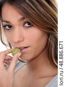 Close-up shot of woman eating grapes. Стоковое фото, агентство Ingram Publishing / Фотобанк Лори