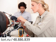 Woman fixing a television. Стоковое фото, агентство Ingram Publishing / Фотобанк Лори