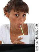 Woman drinking through at work. Стоковое фото, агентство Ingram Publishing / Фотобанк Лори