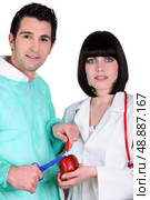 Doctors curing an apple. Стоковое фото, агентство Ingram Publishing / Фотобанк Лори