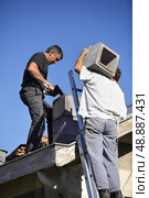 Two roofers hard at work. Стоковое фото, агентство Ingram Publishing / Фотобанк Лори