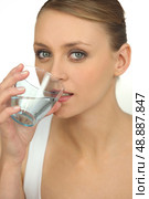 Blond drinking glass of water. Стоковое фото, агентство Ingram Publishing / Фотобанк Лори