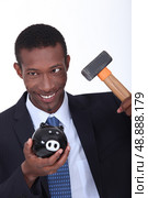 Man hammering open a piggy bank. Стоковое фото, агентство Ingram Publishing / Фотобанк Лори