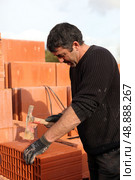 Builder shaping a brick. Стоковое фото, агентство Ingram Publishing / Фотобанк Лори