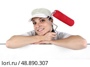 Woman holding a paint roller. Стоковое фото, агентство Ingram Publishing / Фотобанк Лори