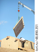 Crane lifting wooden wall. Стоковое фото, агентство Ingram Publishing / Фотобанк Лори