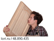 Man nuzzling a hand-crafted piece of wood. Стоковое фото, агентство Ingram Publishing / Фотобанк Лори