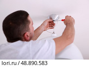 Man repairing ceiling light with screwdriver. Стоковое фото, агентство Ingram Publishing / Фотобанк Лори