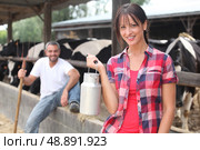 Woman with a churn of milk in front of a herd of cows. Стоковое фото, агентство Ingram Publishing / Фотобанк Лори
