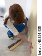 Woman smoothing down wallpaper. Стоковое фото, агентство Ingram Publishing / Фотобанк Лори
