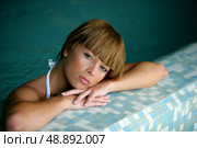 Woman leaning against the edge of a swimming pool. Стоковое фото, агентство Ingram Publishing / Фотобанк Лори