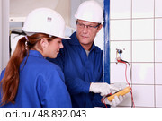 an electrician teaching how to use an ammeter. Стоковое фото, агентство Ingram Publishing / Фотобанк Лори