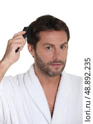 Man combing hair. Стоковое фото, агентство Ingram Publishing / Фотобанк Лори