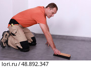 A man laying lino. Стоковое фото, агентство Ingram Publishing / Фотобанк Лори