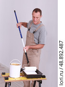 Man applying paint to roller. Стоковое фото, агентство Ingram Publishing / Фотобанк Лори
