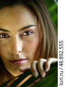 Close-up of woman touching leaf. Стоковое фото, агентство Ingram Publishing / Фотобанк Лори