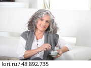 Woman sitting on the floor with a cup of coffee. Стоковое фото, агентство Ingram Publishing / Фотобанк Лори