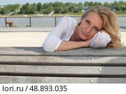 Woman sitting on a bench. Стоковое фото, агентство Ingram Publishing / Фотобанк Лори