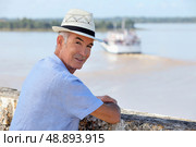 Man in a straw hat watching a ferry cross the Gironde estuary. Стоковое фото, агентство Ingram Publishing / Фотобанк Лори