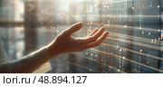 A persons hand reaches out through a window with light glowing on it, with a background of a windowpane. Стоковое AI-изображение, AI-художник Данила Большаков / Фотобанк Лори