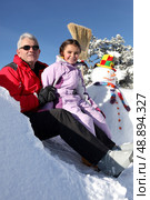 Father and daughter with snowman. Стоковое фото, агентство Ingram Publishing / Фотобанк Лори