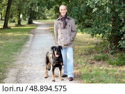 Senior man walking his dog in the woods. Стоковое фото, агентство Ingram Publishing / Фотобанк Лори