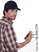 Tradesman holding a multimeter. Стоковое фото, агентство Ingram Publishing / Фотобанк Лори