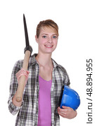 young female bricklayer posing with pickaxe and hard hat. Стоковое фото, агентство Ingram Publishing / Фотобанк Лори