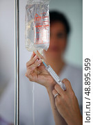 Nurse preparing saline drip. Стоковое фото, агентство Ingram Publishing / Фотобанк Лори