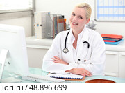 Doctor sitting behind her desk. Стоковое фото, агентство Ingram Publishing / Фотобанк Лори